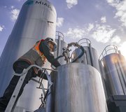 An employee checks the fermentation process in the 1000L bioreactors, next to the 30,000L bioreactors at MiAlgae's Commercial Demonstrator site.